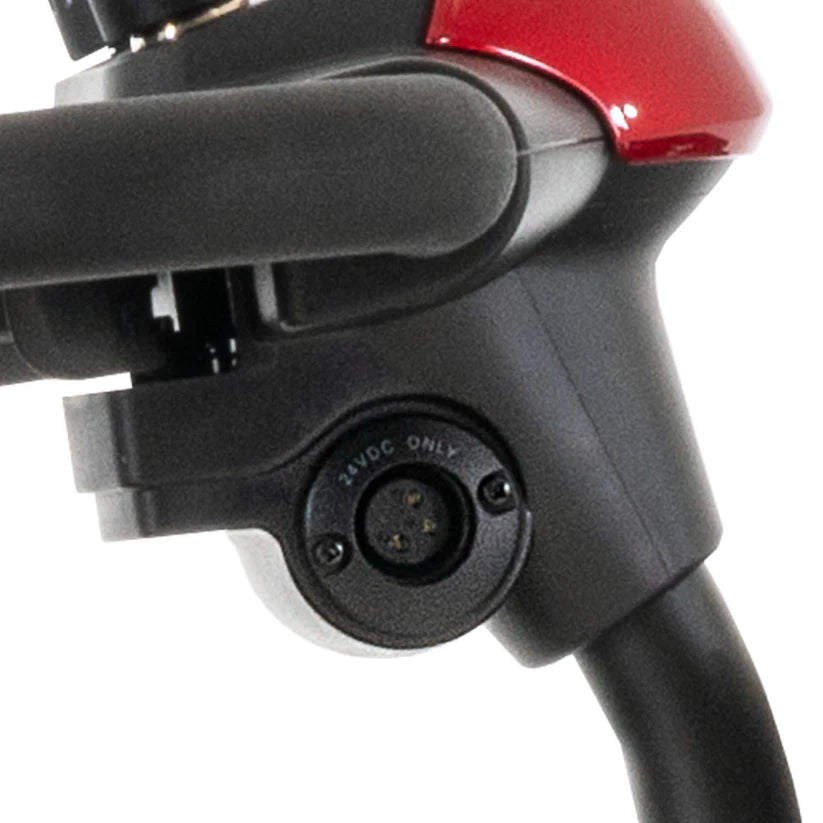 Close-up of the charging port on the Pride Mobility Go Go Elite Traveller 3-Wheel scooter in black and red