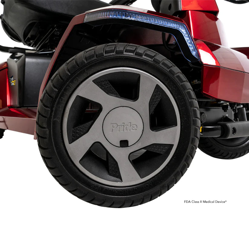 Close-up of the rear wheel on a red Pride Zero Turn 10 Mobility Scooters with black tire and rim